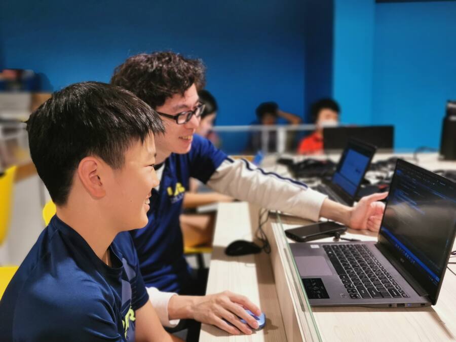 A Lab instructor helping a student with a coding project on a laptop